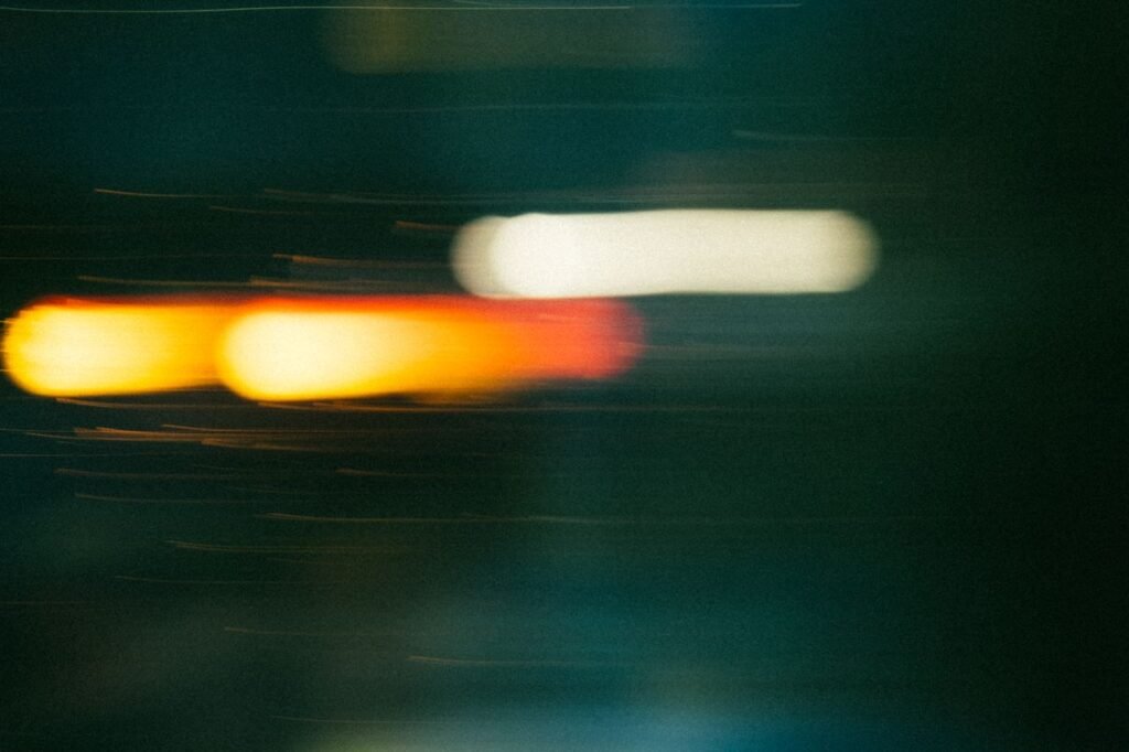 Layanan A dynamic abstract image capturing the blurred motion of colorful neon lights at night.